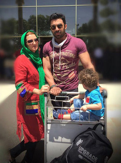 عکس خانوادگی روناک یونسی با چرخ حمل بار در محوطه فرودگاه