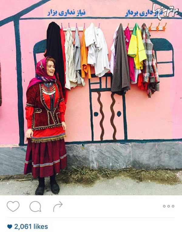 الناز حبیبی در کنار دیوار مهربانی منتظر است تا یک نفر لباسی مناسب سایزش را بیاورد و روی دیوار بگذارد