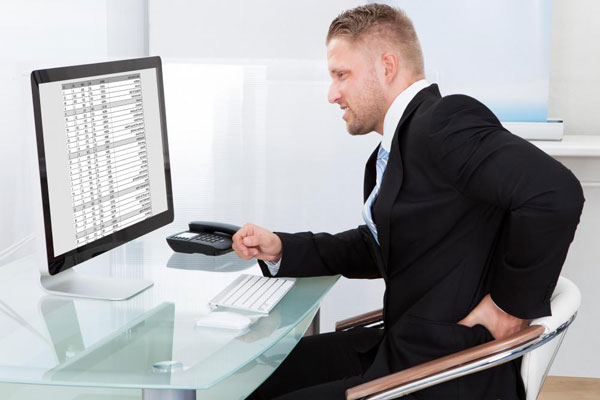 man-in-black-suit-sitting-at-computer-with-lower-back-pain
