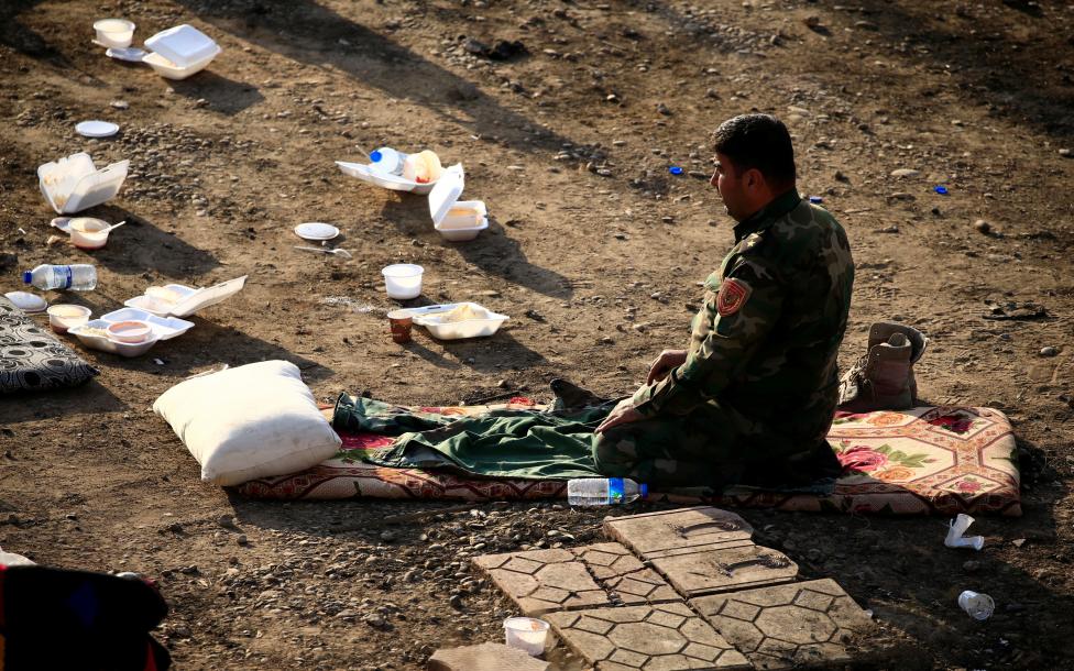 A member of Peshmerga forces pray in the town of Bashiqa, east of Mosul