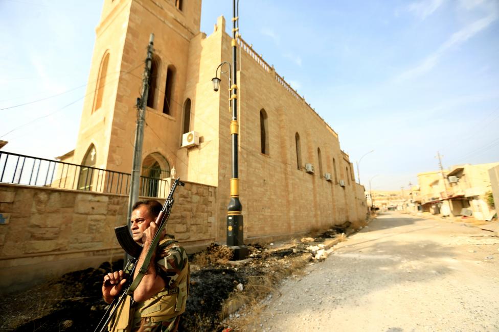 A member of Peshmerga forces stands outside the Mart Shmoni Church since it was recaptured from the Islamic State in the town of Bashiqa