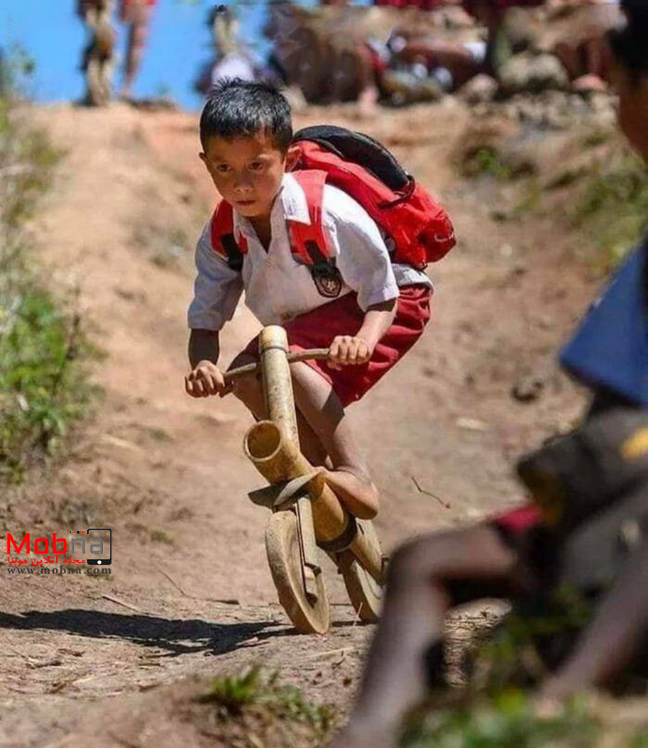 کودک اندونزیایی در حال سواری با دوچرخه دست ساز خودش (عکس)